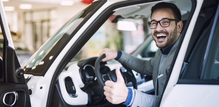 Happy satisfied customer just bought a brand new car at vehicle dealership.