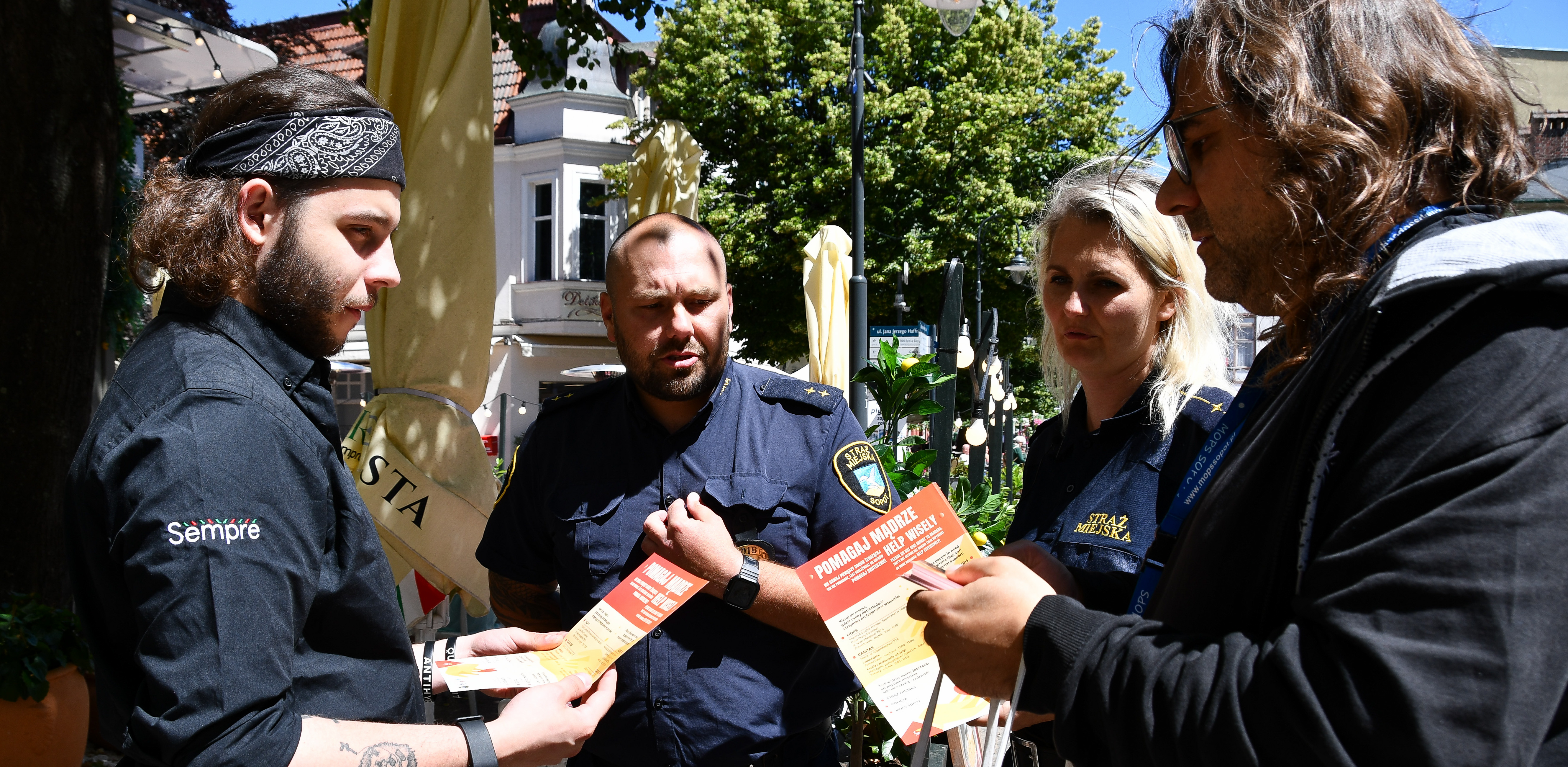 Maciej Azarewicz z MOPS Sopot (po prawej) i strażnicy miejscy rozdają ulotki w ramach sopockiej kampanii "Pomagaj Mądrze" (fot. UM Sopot)