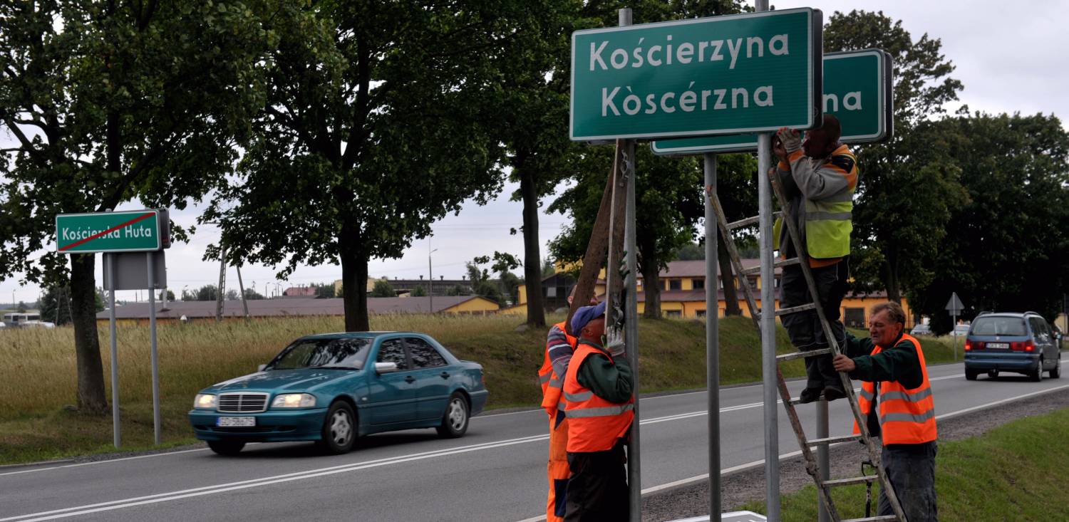 Zdjęcie archiwalne z roku 2013. Wymiana tablic przy wjeździe do Kościerzyny na nowe w dwóch językach, po polsku i po kaszubsku. Nz. wjazd od strony Żukowa (fot. Maciej Kosycarz / KFP)