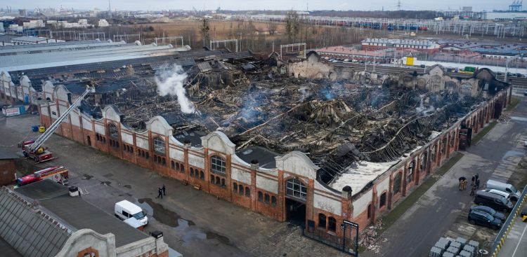 Gdańsk, 06.02.2025. Miejsce pożaru hali na gdańskiej Przeróbce, 6 bm. Pożar w budynku dawnych Zakładów Naprawczych Taboru Kolejowego wybuchł 5 bm. Przed przyjazdem służb z budynku ewakuowało się ok. 60 osób. (Fot. PAP/Adam Warżawa)