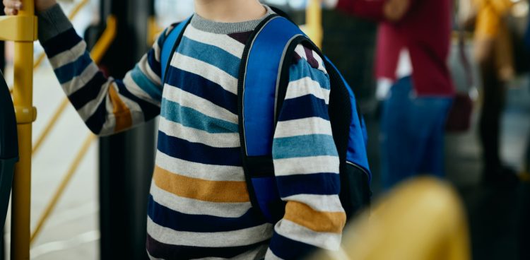 Zdjęcie ilustracyjne, uczeń podstawówki w autobusie (fot. Freepik)