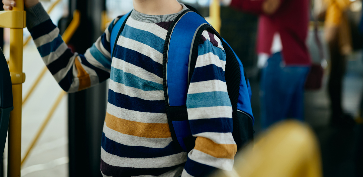 Zdjęcie ilustracyjne, uczeń podstawówki w autobusie (fot. Freepik)