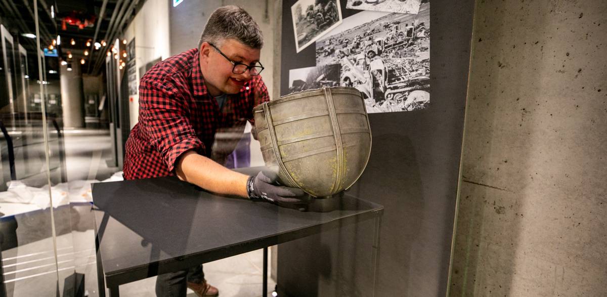 Dr Wojciech Łukaszun, kierownik Działu Zbiorów i Digitalizacji Muzeum II Wojny Światowej prezentuje czerpak zrobiony z niemieckiego hełmu (fot. Muzeum II Wojny Światowej w Gdańsku)