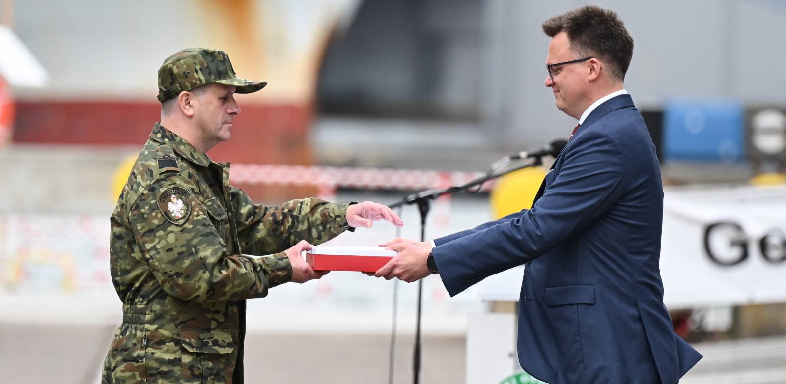 Marszałek Sejmu Szymon Hołownia (P) oraz dowódca Morskiego Oddziału Straży Granicznej kontradm. SG Andrzej Prokopski (L) podczas uroczystego apelu z okazji przekazania Flagi RP Morskiemu Oddziałowi Straży Granicznej w Gdańsku, 03.07.2025 r. (fot. PAP/Adam Warżawa)