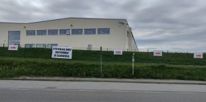 Na płocie otaczającym budynek firmy zawisły flagi z logotypem Solidarności i hasłami (fot. Radio Gdańsk/Filip Jędruch)