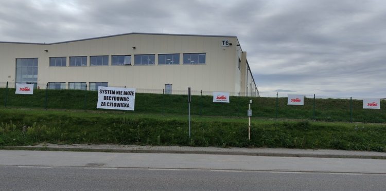 Na płocie otaczającym budynek firmy zawisły flagi z logotypem Solidarności i hasłami (fot. Radio Gdańsk/Filip Jędruch)