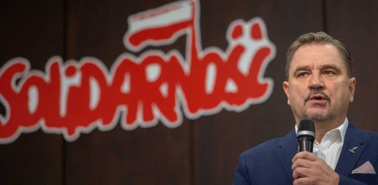 Przewodniczący NSZZ "Solidarność" Piotr Duda obok znaku graficznego Związku (fot. KFP/Anna Rezulak)