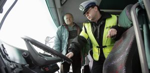 Zdjęcie archiwalne. Policjant sprawdza autokar wiozący dzieci na ferie (fot. Wojtek Jakubowski /KFP