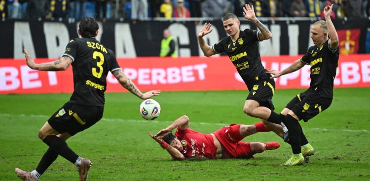 Piłkarze Arki Gdynia Dawid Gojny (P) i Oskar Kubiak (2L) oraz Marcel Krajewski (2L) z Widzewa Łódź podczas meczu Ekstraklasy. Gdynia, 15.03.2026 r. (fot PAP/Adam Warżawa)