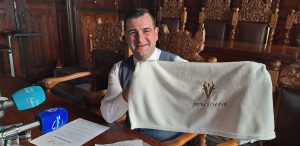 Adam Kopczyński, zastępca burmistrza Chojnic z kocykiem, który otrzymają w wyprawce nowo narodzeni Chojniczanie (fot. Radio Gdańsk/Maria Sowisło)