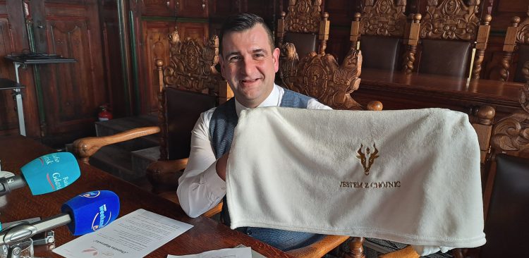 Adam Kopczyński, zastępca burmistrza Chojnic z kocykiem, który otrzymają w wyprawce nowo narodzeni Chojniczanie (fot. Radio Gdańsk/Maria Sowisło)