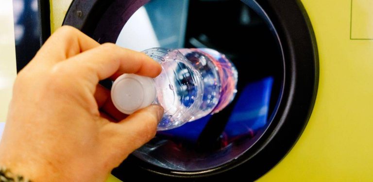 Ręka człowieka wrzucającego butelkę do butelkomatu