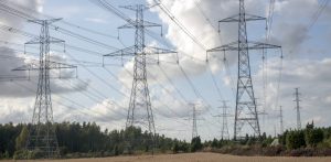 Trzy słupy linii energetycznych stojące na polu