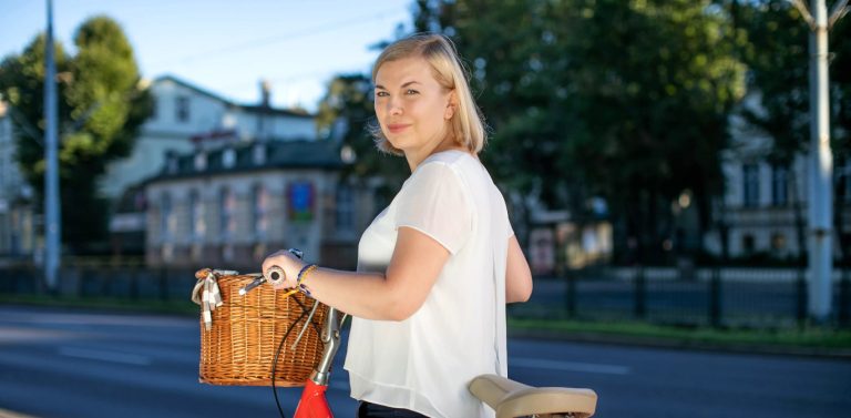 Celina Zboromirska-Bieńczak na rowerze, w tle siedziba Teatru Miniatura