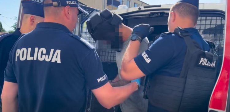 Policja wprowadza podejrzanego o zabójstwo do radiowozu