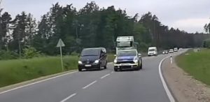 Radiowóz, bez włączonych sygnałów uprzywilejowania, wyprzedza kolumnę pojazdów