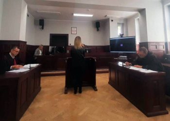 Sala rozpraw Sądu Okręgowego w Słupsku. Przy stołach siedzą prawnicy w togach, na środku tyłem stoi kobieta, a po prawej stronie na ławie siedzi oskarżony kierowca z czarnym paskiem zasłaniającym oczy. Zapada wyrok w sprawie śmiertelnego wypadku w czasie orkanu Ksawery w 2013 roku