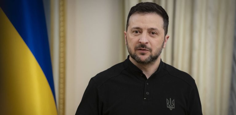 Wołodymyr Zelenski, w tle flaga Ukrainy