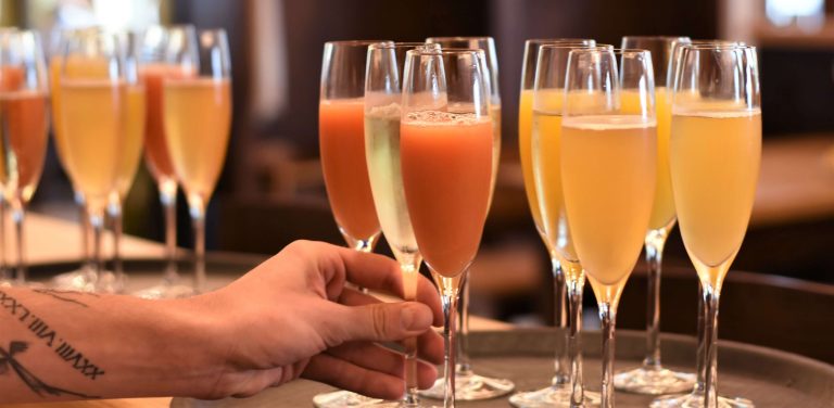 Człowiek sięgający po kieliszek z alkoholem