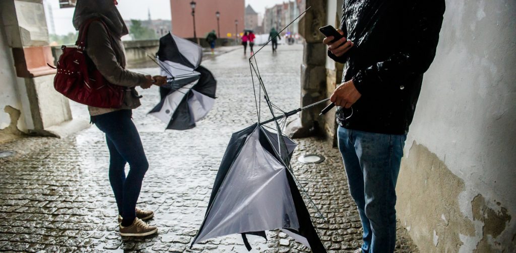 Połamane przez silne porywy wiatru parasolki w rękach przechodniów. Alert RCB obejmuje też burze i intensywne opady deszczu