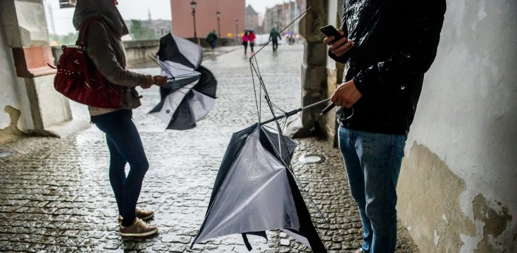 Połamane przez silne porywy wiatru parasolki w rękach przechodniów. Alert RCB obejmuje też burze i intensywne opady deszczu