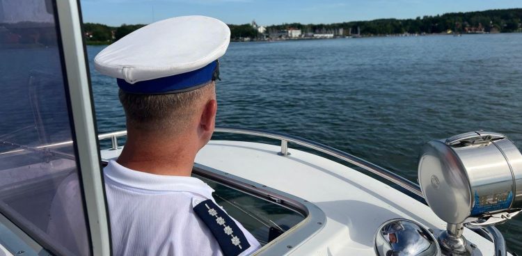 Policyjny patrol na Jeziorze Charzykowskim. Policjant na łódce