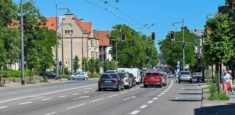 Widok na Aleję Niepodległości w Sopocie z ruchem samochodowym, trakcją trolejbusową i kamienicami w słoneczny dzień. Zdjęcie jest ilustracją do wiadomości o zmianach w organizacji ruchu w związku z kolejnym etapem remontu
