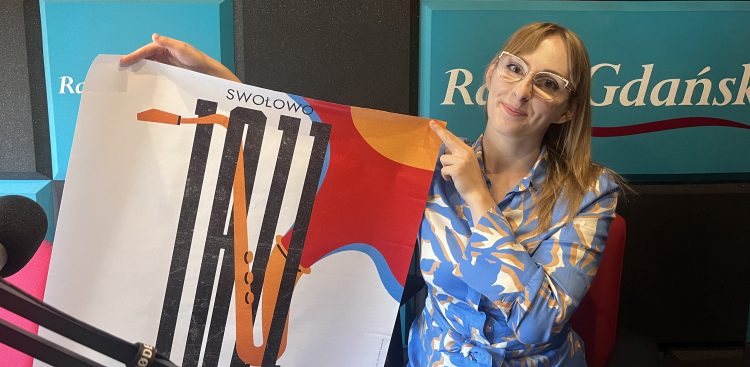 Uśmiechnięta kobieta w okularach i niebiesko-białej bluzce prezentuje i wskazuje plakat festiwalu "Swołowo Jazz (to Gabriela Kalinowska z Centrum Kultury i Biblioteki Gminy Redzikowo). Kobieta znajduje się w studiu radiowym, w tle widać logo Radia Gdańsk, a z lewej strony widoczny jest mikrofon