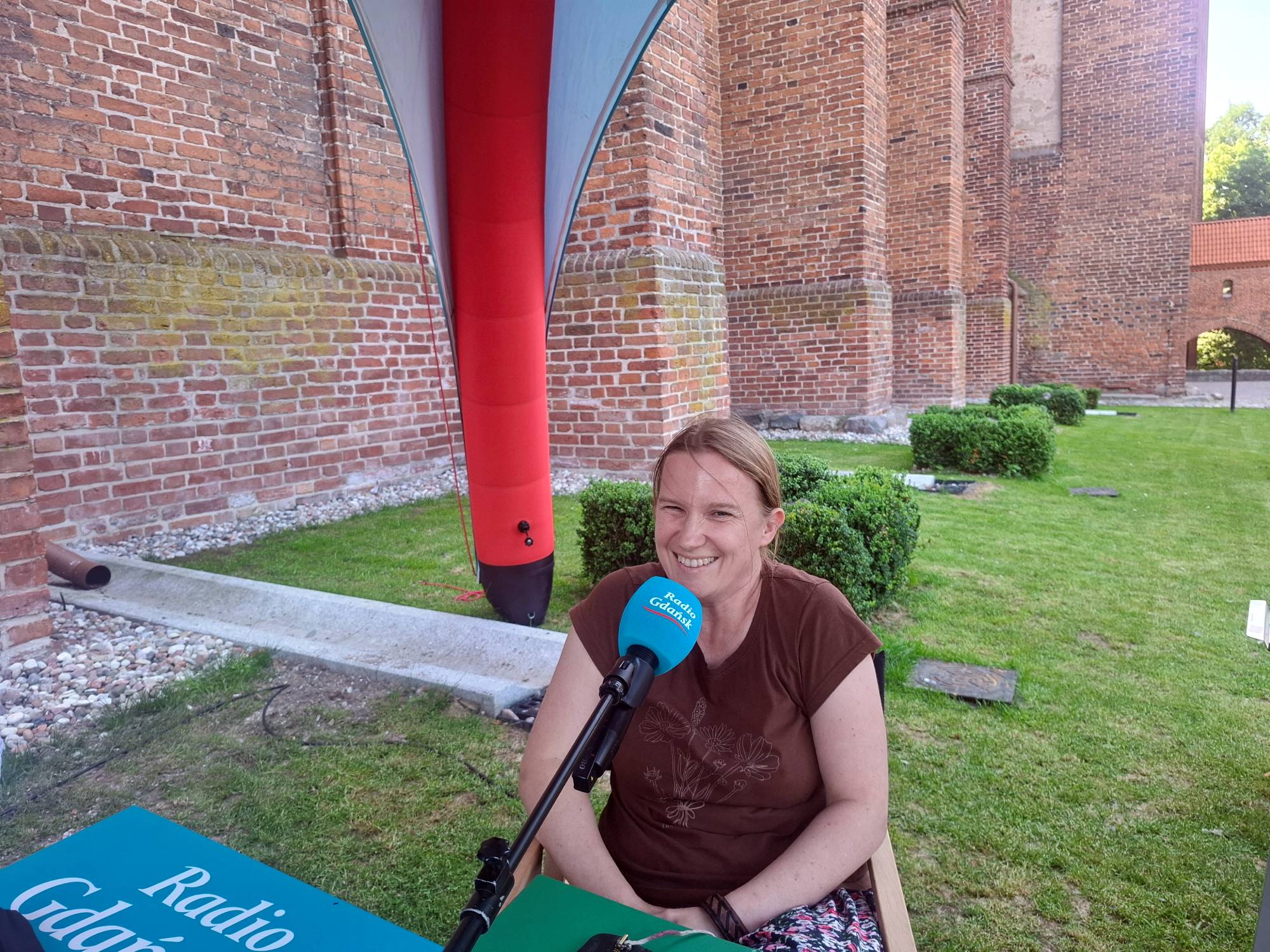 Joanna Jezierska, kustosz muzeum zamkowego w Kwidzynie przed mikrofonem Radia Gdańsk w plenerowym studiu przy murach zamku w Malborku