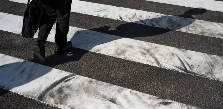 Pieszy przechodzący przez ulicę na pasach