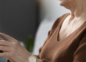 Seniorka trzyma w dłoniach telefon