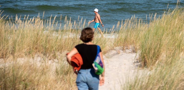 Plaża w Helu. Turystka idzie w stronę morza