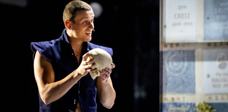 Aktor Paweł Charyton w granatowej kamizelce, trzymający oburącz ludzką czaszkę na ciemnej scenie teatralnej podczas spektaklu „Hamlet”. Teatr Zagłębia w Sosnowcu zdobył nagrodę Złotego Yoricka na zakończonym w niedzielę 30. międzynarodowym Festiwalu Szekspirowskim w Gdańsku