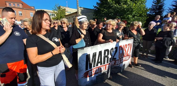 Uczestnicy marszu milczenia w Miastku trzymają transparent z napisem "Marsz Ciszy. Ostatni dyżur dla szpitala"