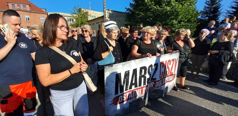 Uczestnicy marszu milczenia w Miastku trzymają transparent z napisem "Marsz Ciszy. Ostatni dyżur dla szpitala"