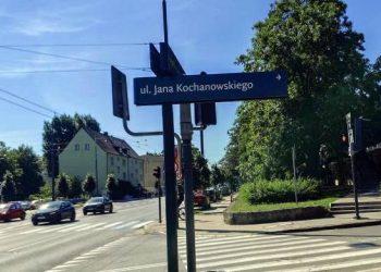 Skrzyżowanie Al. Niepodległości z ul. Jana Kochanowskiego w Sopocie. Na pierwszym planie widoczny jest słupek ze znakiem "ul. Jana Kochanowskiego", w tle wielopasmowa jezdnia z jadącymi samochodami, przejście dla pieszych, drzewa oraz budynki w słoneczny dzień. Urząd Miasta Sopotu zapowiedział remont Al. Niepodległości, który spowoduje utrudnienia w ruchu samochodowym