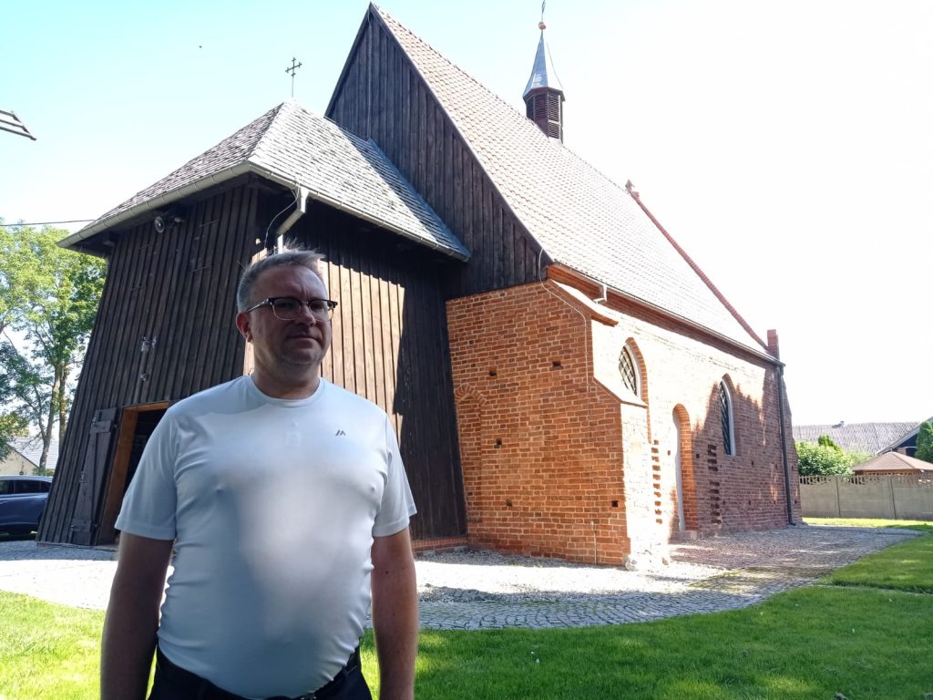 Arkadiusz Dekański przed budynkiem kościoła świętej Barbary
