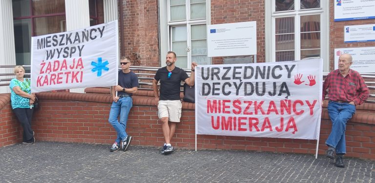 Mieszkańcy wyspy Sobieszewskiej zorganizwoali pikiete. Na plakatach widać napisy "Mieszkańcy wyspy żądają karetki", "Urzędnicy decydują, mieszkańcy umierają"