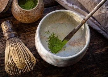 Czym jest matcha? Matcha to tak naprawdę sproszkowana zielona herbata. Powstaje z liści właściwych krzewu kamelii chińskiej. Na zdjęciu kubek matchy i pędzelek.