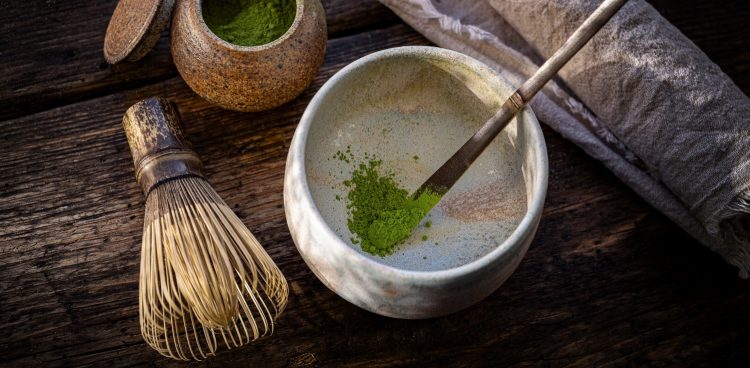 Czym jest matcha? Matcha to tak naprawdę sproszkowana zielona herbata. Powstaje z liści właściwych krzewu kamelii chińskiej. Na zdjęciu kubek matchy i pędzelek.