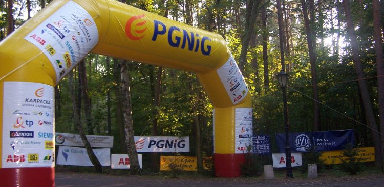 Duży, żółty reklamowy balon. W tle las