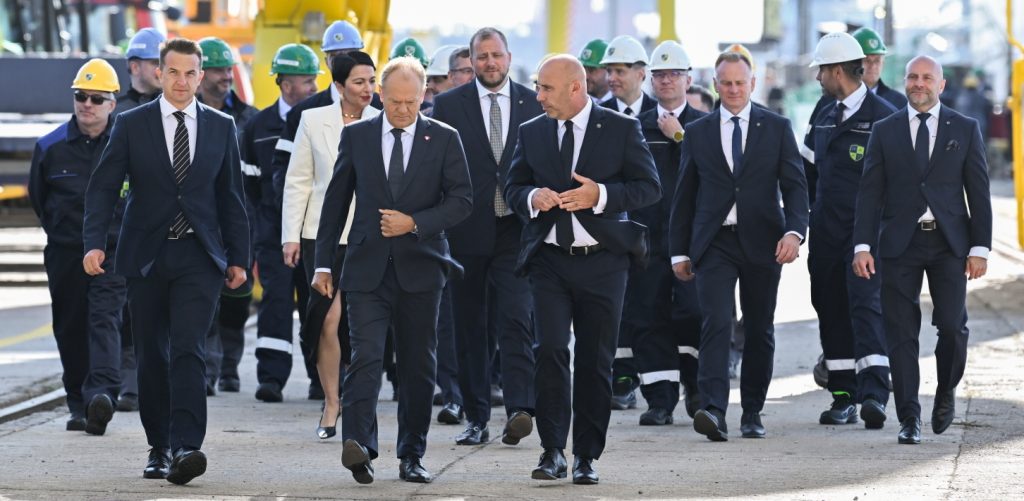 Gdynia, 12.08.2026. Premier Donald Tusk (centrum-L), rzecznik rządu Adam Szłapka (L), prezes PGZ Stoczni Wojennej Marcin Ryngwelski (C-w tle) i prezes Polskiej Grupy Zbrojeniowej Adam Leszkiewicz (centrum-P) podczas wizyty w PGZ Stoczni Wojennej w Gdyni, 12 bm. Premier Donald Tusk spotkał się z pracownikami, którzy brali udział w budowie fregaty Wicher. (mr) PAP/Andrzej Jackowski