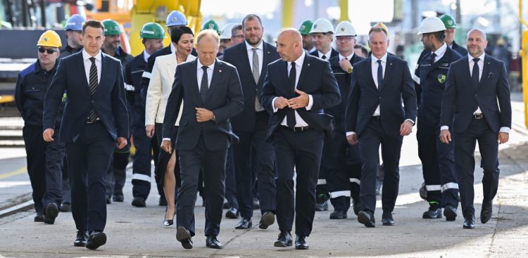 Gdynia, 12.08.2026. Premier Donald Tusk (centrum-L), rzecznik rządu Adam Szłapka (L), prezes PGZ Stoczni Wojennej Marcin Ryngwelski (C-w tle) i prezes Polskiej Grupy Zbrojeniowej Adam Leszkiewicz (centrum-P) podczas wizyty w PGZ Stoczni Wojennej w Gdyni, 12 bm. Premier Donald Tusk spotkał się z pracownikami, którzy brali udział w budowie fregaty Wicher. (mr) PAP/Andrzej Jackowski