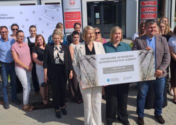 Grupa osób stoi przed Urzędem Gminy Parchowo. Trzymają wspólnie czek z napisem "USUWANIE WYROBÓW ZAWIERAJĄCYCH AZBEST. 1 593 572 ZŁ DLA WOJEWÓDZTWA POMORSKIEGO"