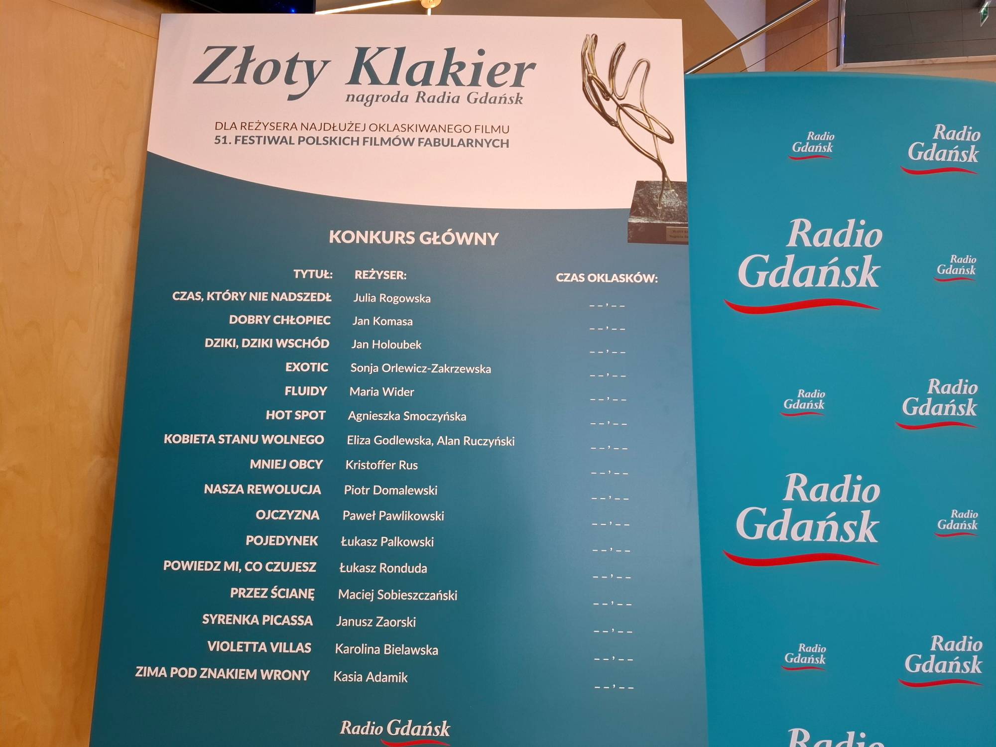 Tablica nagrody Radia Gdańsk „Złoty Klakier” na 51. FPFF z listą 16 filmów Konkursu Głównego oraz pustymi polami na wpisanie zmierzonych czasów oklasków publiczności