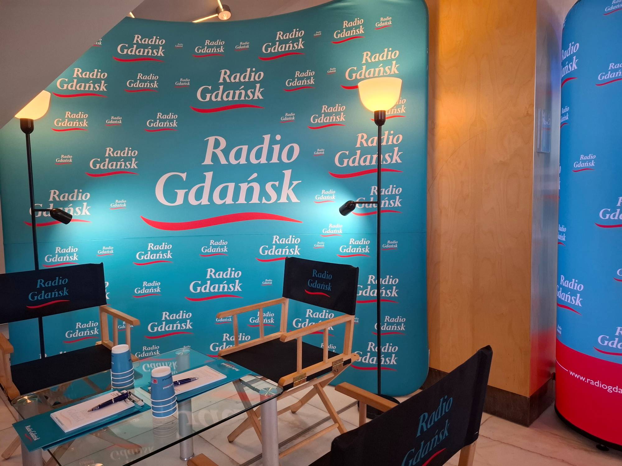 Festiwalowe Studio Radia Gdańsk przygotowane na 51. FPFF w Teatrze Muzycznym - ścianka z logo stacji, fotele reżyserskie, lampy oraz stolik z radiowymi materiałami