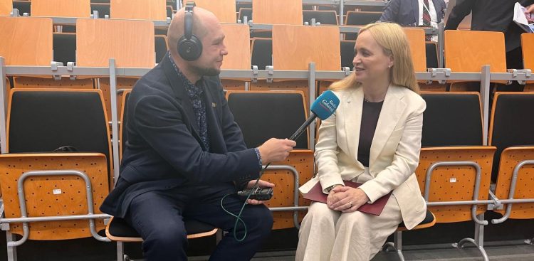 Na zdjęciu mężczyzna w słuchawkach trzyma mikrofon przy kobiecie, która się uśmiecha.