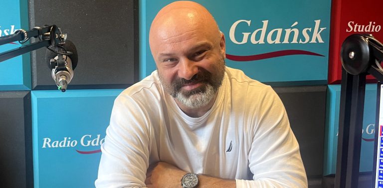 Uśmiechnięty, łysy mężczyzna z siwiejącą brodą w białej bluzce – ratownik Grzegorz Załupka – siedzi przy mikrofonie w studiu Radia Gdańsk. Specjalista mówił o bezpieczeństwa i i zasadach radzenia sobie przez pierwsze 72 godziny w sytuacjach kryzysowych, takich jak powódź czy ewakuacja