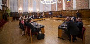 Na zdjęciu Pierwsza Sesja Młodzieżowej Rady Miasta Sopotu w 2022 roku. Młodzież i radni siedzą przy stołach w Urzędzie Miasta.