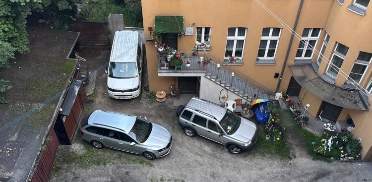 Na zdjęciu widok z góry na budynek i samochody przy ulicy Rybołowców 8 w Gdańsku